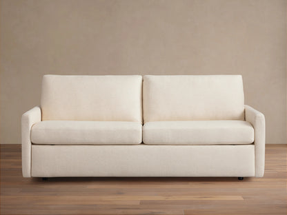 Kipton Luxury Sleeper Sofa in beige fabric, shown from the front with plush seat and back cushions, set on a wooden floor.