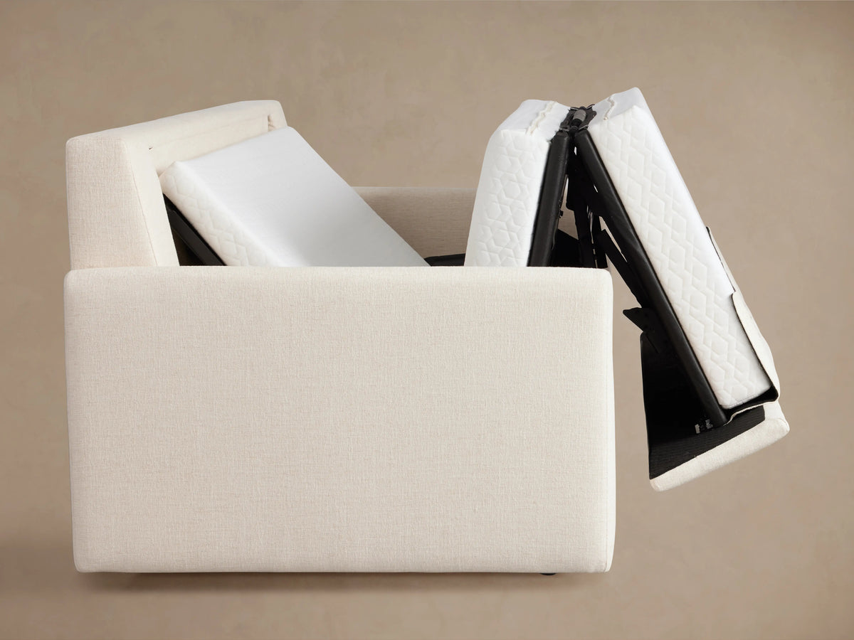 Kipton Luxury Sleeper Sofa with cream upholstery, partially extended into a sleeper. Features a white quilted mattress surface.