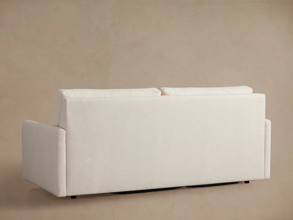 The Kipton Luxury Sleeper Sofa in beige fabric, partially unfolded to show its pull-out mechanism and mattress components.