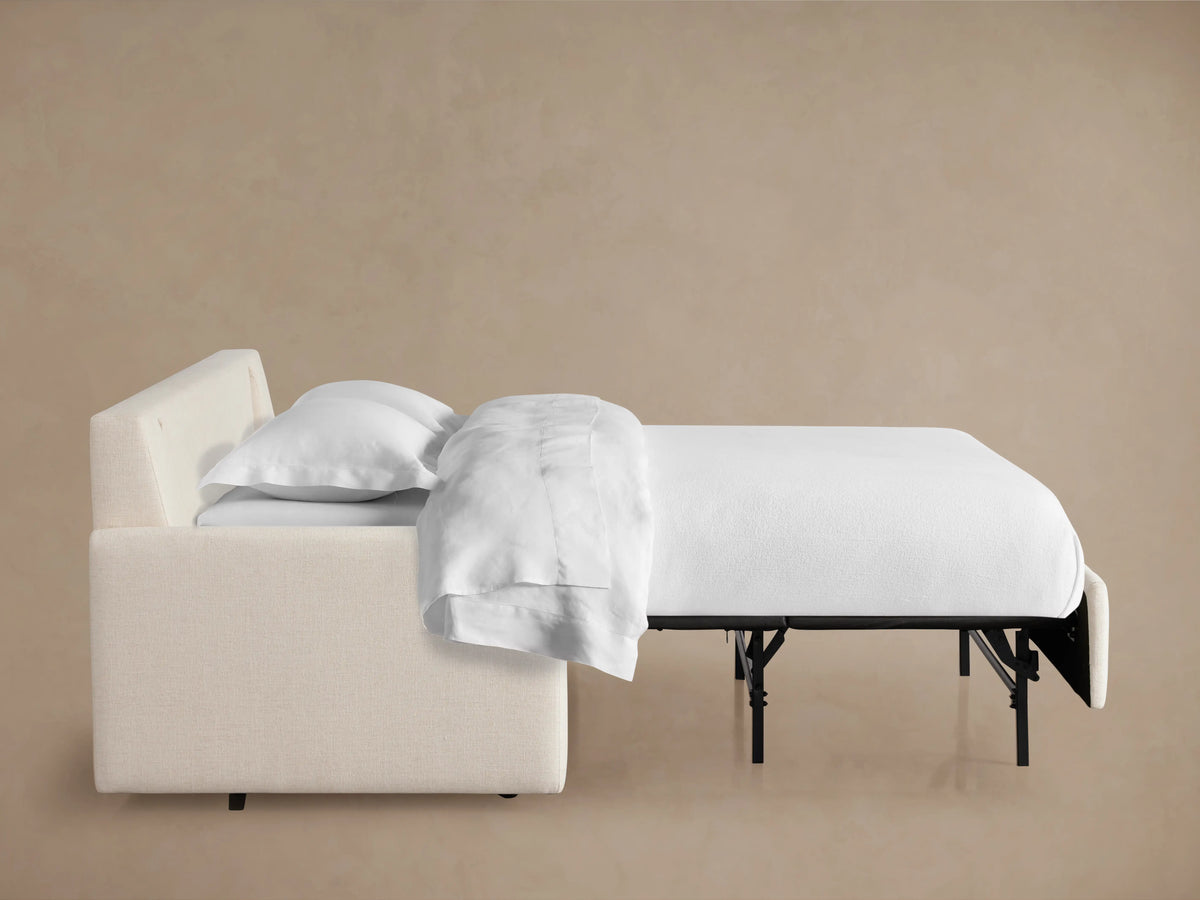 Back view of the Kipton Luxury Sleeper Sofa in a soft cream fabric, featuring a sleek design and plush back cushions.