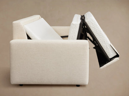 Kipton Wide Arm Luxury Sleeper Sofa in beige fabric, features wide arms, rectangular back cushions, and a sleek wood floor setting.