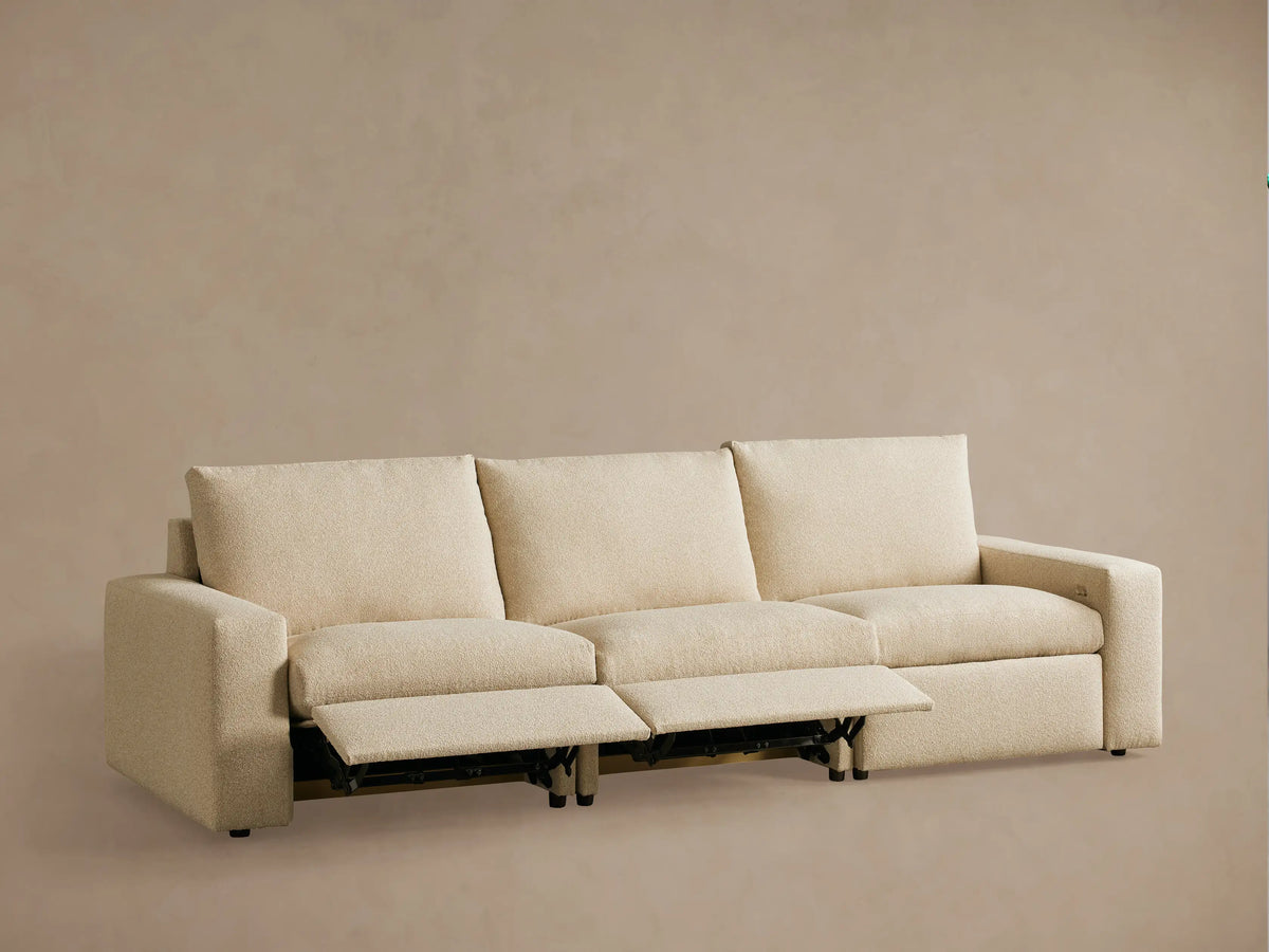 Rear view of the Kipton Wide Arm Three-Piece Motion Modular Sofa in beige fabric, showing wide arms and rectangular backrests.