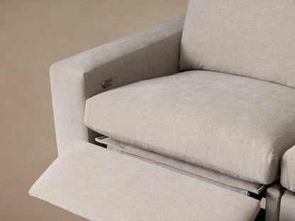 Kipton Wide Arm Four-Piece Motion Sectional, light beige L-shaped sofa with plush cushions and wide arms, on wood floor.