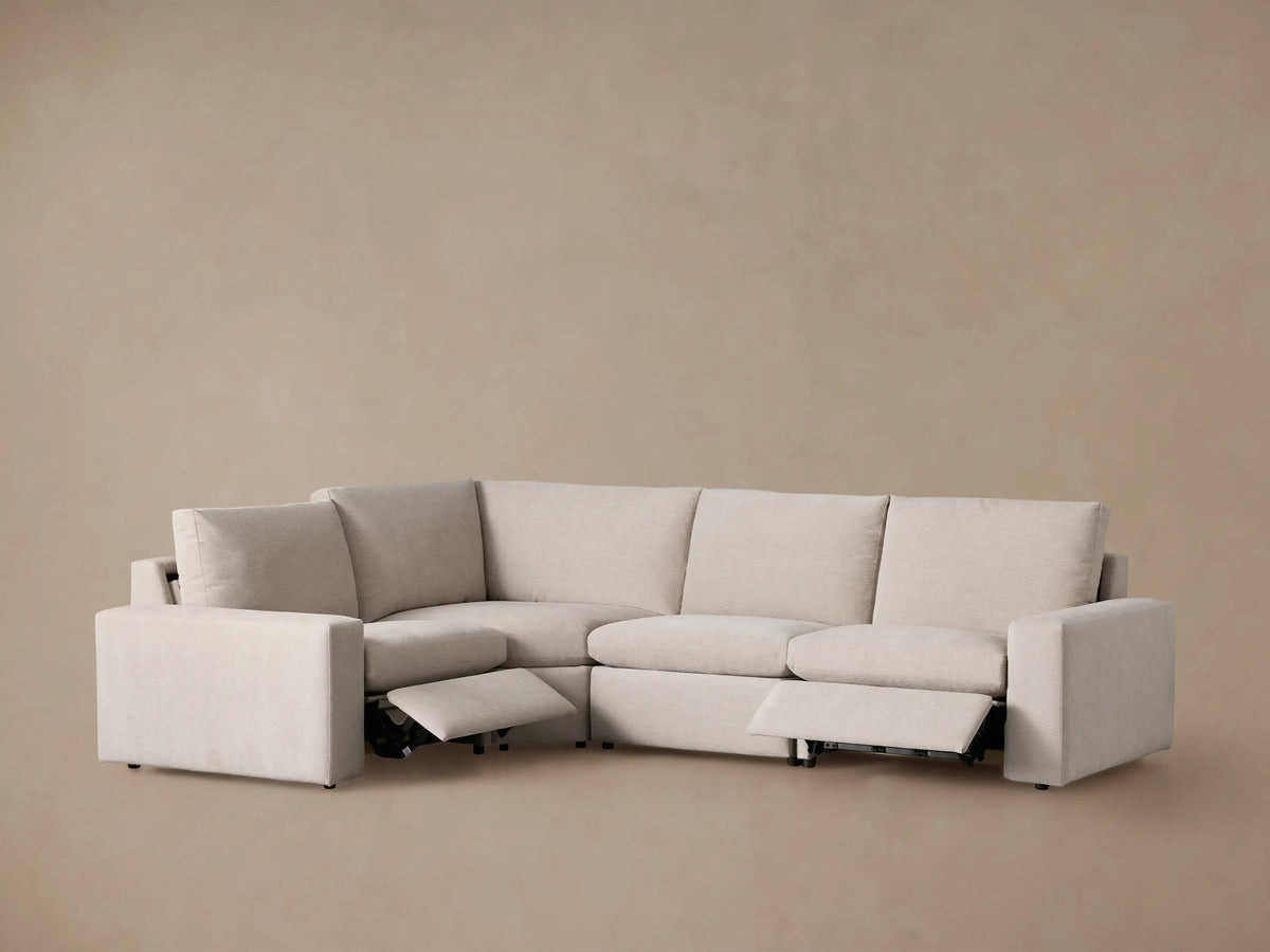 Back-right view of the Kipton Wide Arm Four-Piece Motion Sectional in light beige fabric, showing separate back cushions.