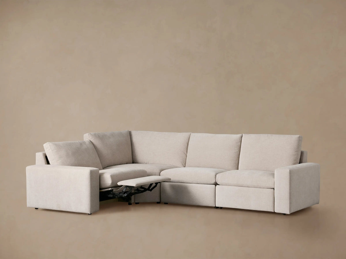 Light beige Kipton Wide Arm Four-Piece Motion Sectional, L-shaped with two extended footrests.