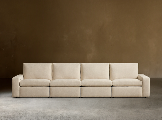Kipton Wide Arm Four-Piece Motion Modular Sofa in beige fabric on wooden floor, straight view, with wide arms and four cushioned seats.