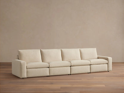 Kipton Wide Arm Four-Piece Motion Modular Sofa in beige fabric on wooden floor, straight view, with wide arms and four cushioned seats.