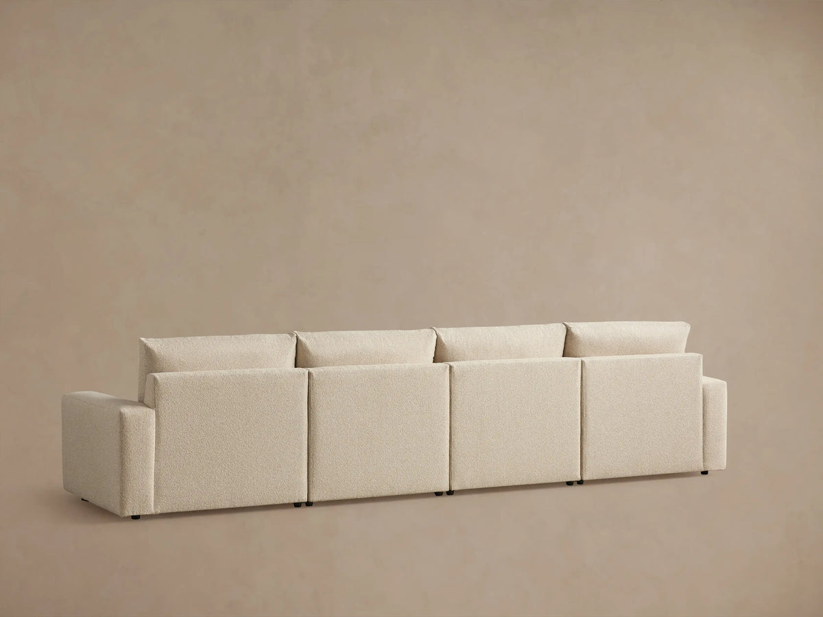 Alt text: Kipton Wide Arm Four-Piece Motion Modular Sofa in textured beige fabric, featuring wide padded armrests and plush cushions, against a neutral background.