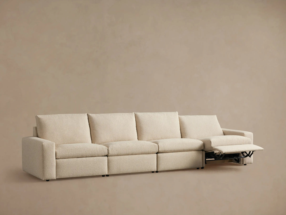 Kipton Wide Arm Four-Piece Motion Modular Sofa in neutral fabric, showing back view with wide arms and four cushion sections.