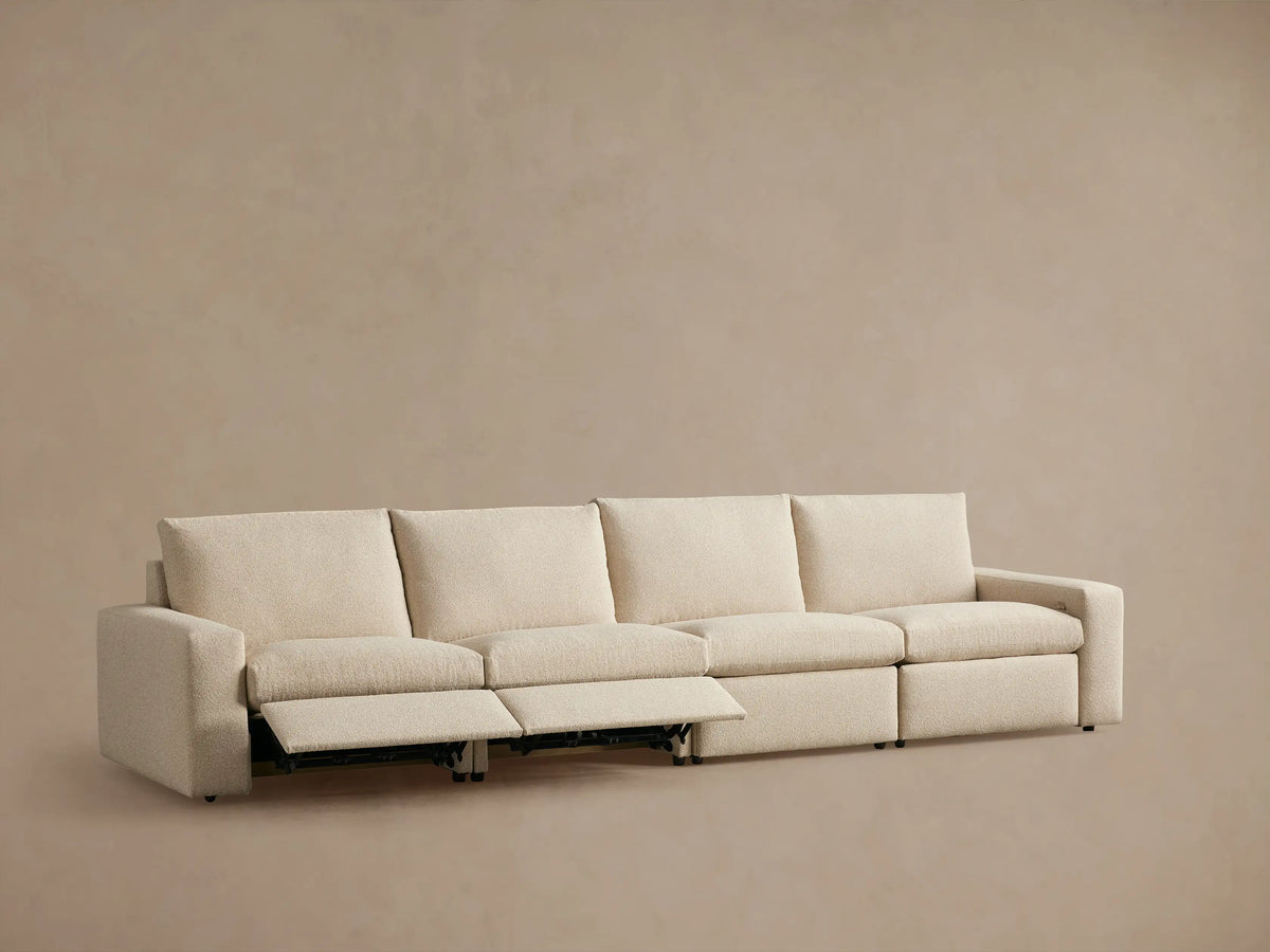 Beige Kipton Wide Arm Modular Sofa with four sections, one reclined, wide armrests, on a neutral backdrop.