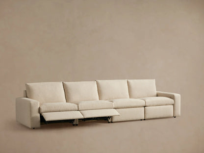 Beige Kipton Wide Arm Modular Sofa with four sections, one reclined, wide armrests, on a neutral backdrop.