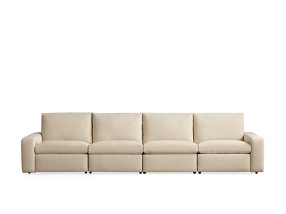 Kipton Wide Arm Sofa, four-piece, beige fabric, wide arms, left segment reclined with footrest elevated. Neutral background.