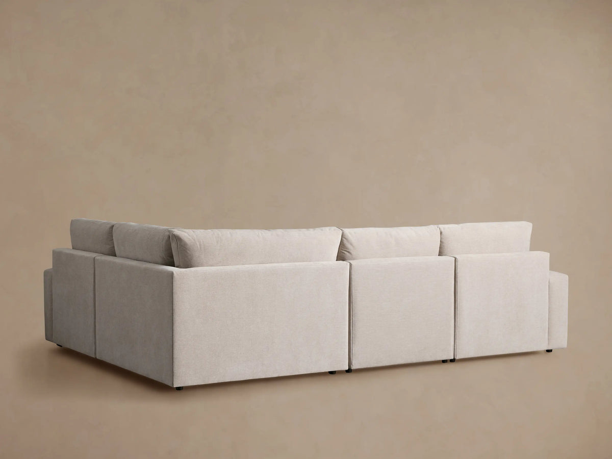 Close-up of a light beige Kipton Wide Arm Motion Sectional. Textured fabric, wide arm, and extended footrest for reclining comfort.