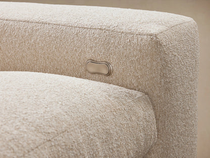 Kipton Wide Arm Four-Piece Motion Sectional in neutral fabric, featuring wide arms and a cushioned back, placed on a wooden floor.
