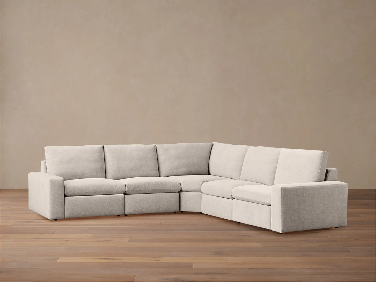 Kipton Wide Arm Five-Piece Motion Corner Sectional, light beige fabric, on wood floor against a neutral wall.