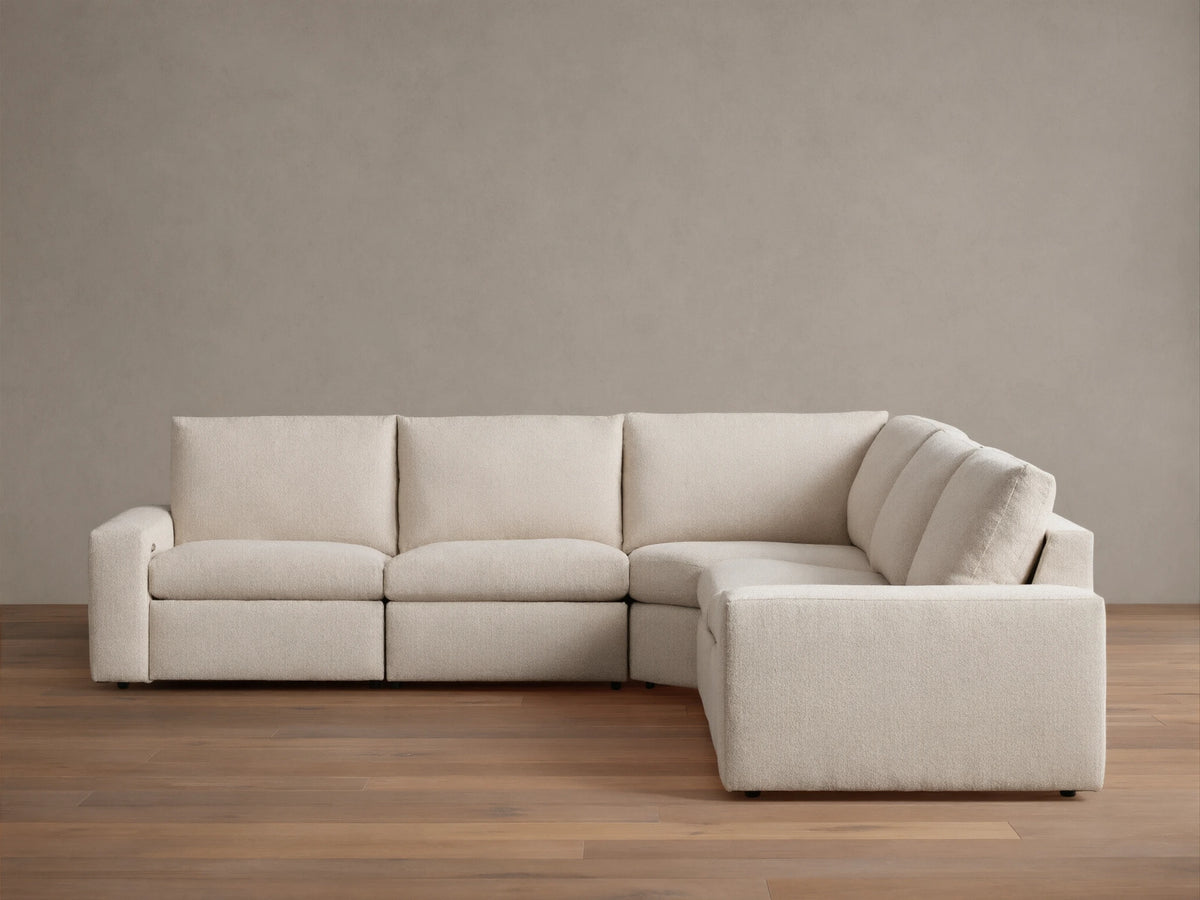Kipton Wide Arm Five-Piece Motion Corner Sectional in beige fabric, featuring wide arms and a sleek L-shape design on wooden flooring.