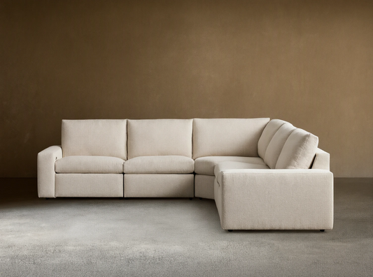 Kipton Wide Arm Five-Piece Motion Corner Sectional in beige fabric, featuring wide arms and a sleek L-shape design on wooden flooring.