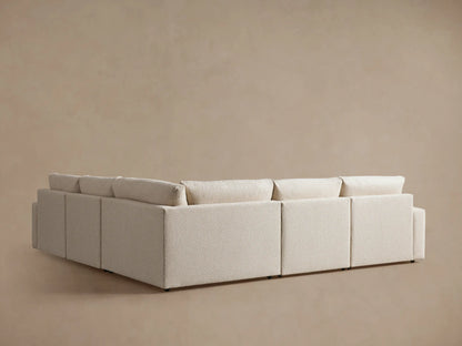 Kipton Wide Arm Five-Piece Motion Corner Sectional in cream color, showing the back and side view with wide arms and cushioned backrests against a neutral background.