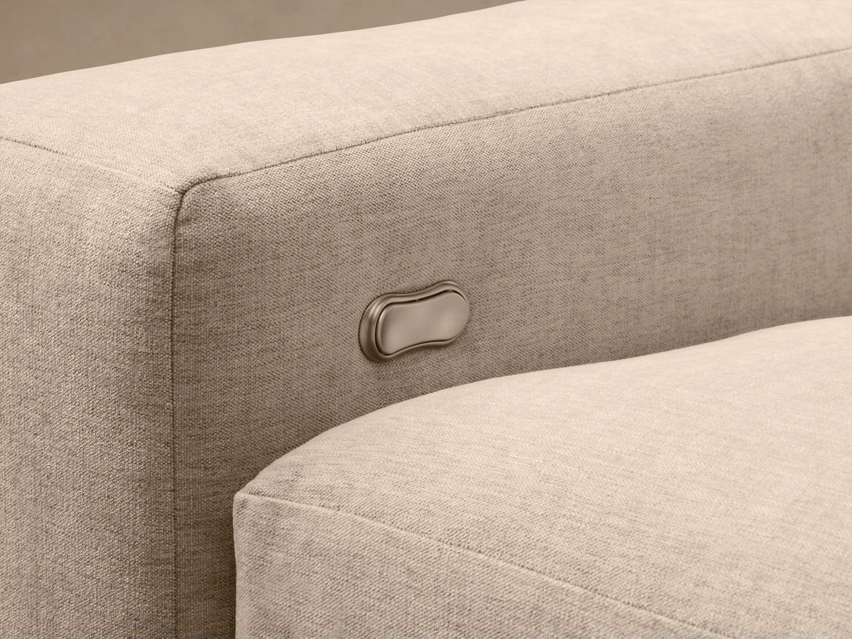 Kipton Wide Arm Sectional in beige fabric with extended footrest, button control on the armrest, and wide design.