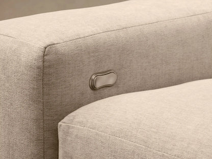 Kipton Wide Arm Sectional in beige fabric with extended footrest, button control on the armrest, and wide design.