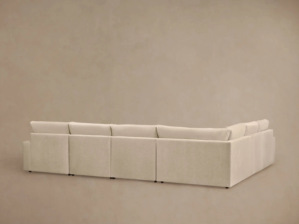 Kipton Wide Arm Six Piece Motion Sectional in beige fabric, six seats connected, left section reclined, on neutral backdrop.