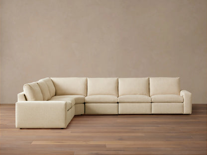 Kipton Wide Arm Six Piece Motion Sectional in beige fabric, L-shaped with wide arms, set on wooden floor against a plain backdrop.