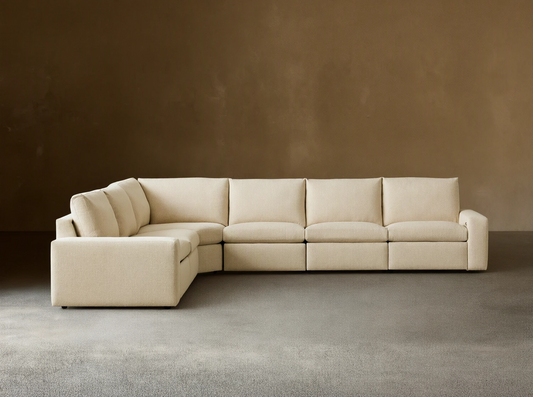 Kipton Wide Arm Six Piece Motion Sectional in beige fabric, L-shaped with wide arms, set on wooden floor against a plain backdrop.