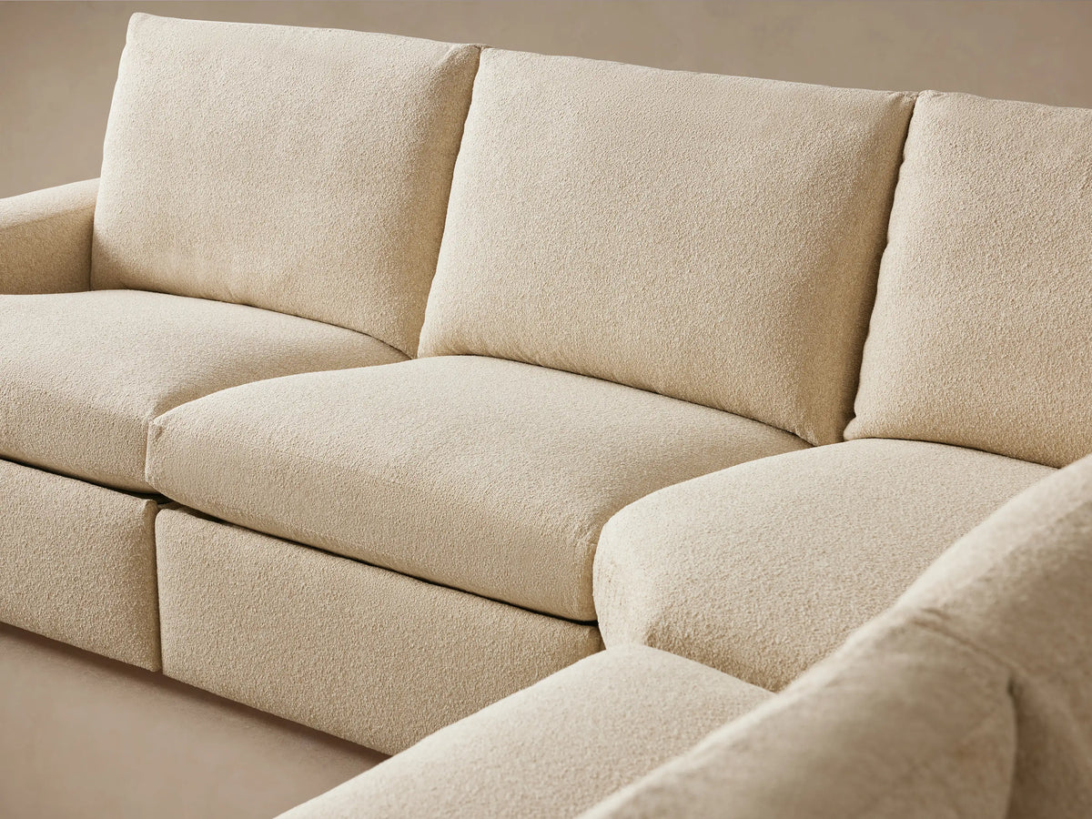 Beige fabric arm of the Kipton Wide Arm Six Piece Motion Sectional with visible two-button motion control on the side.