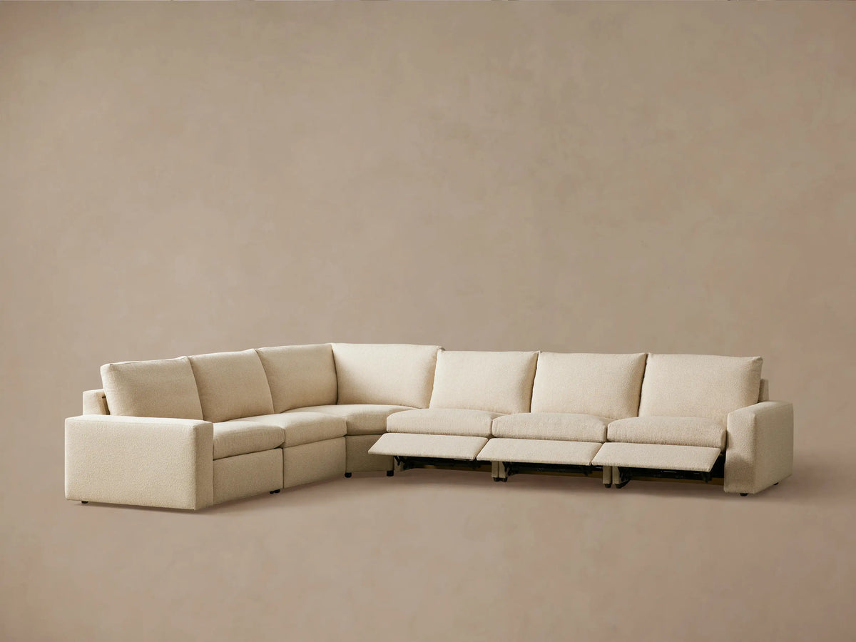 Kipton Wide Arm Six Piece Motion Sectional in beige fabric, viewed from the back. The sectional has wide arms and a smooth texture.