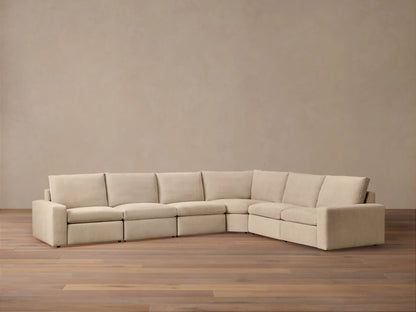 Full view of L-shaped Kipton Wide Arm Six Piece Motion Sectional in light beige, with wide arms & plush cushions on wood floor.