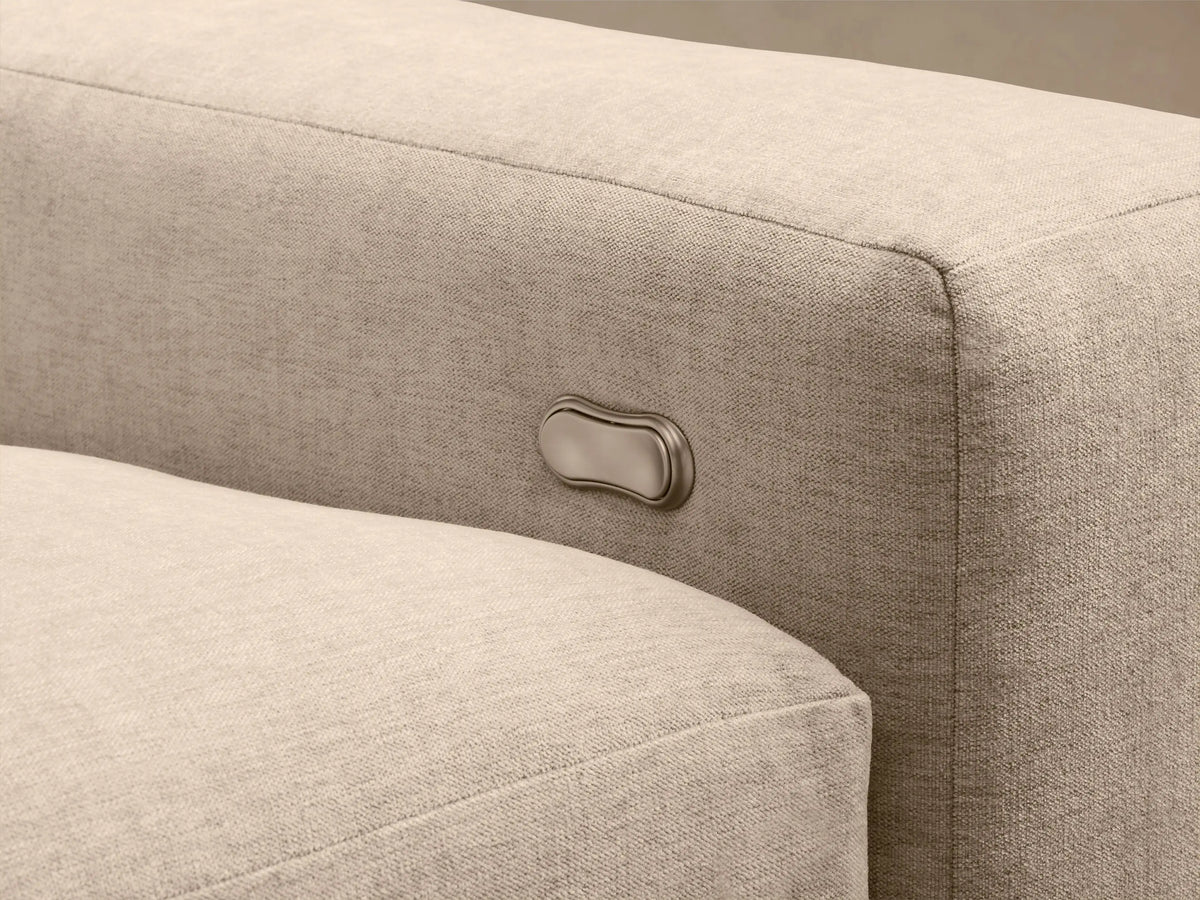 Kipton Wide Arm Six-Piece Motion Sectional, upholstered in light beige fabric, arranged in an L-shape on a wood floor.