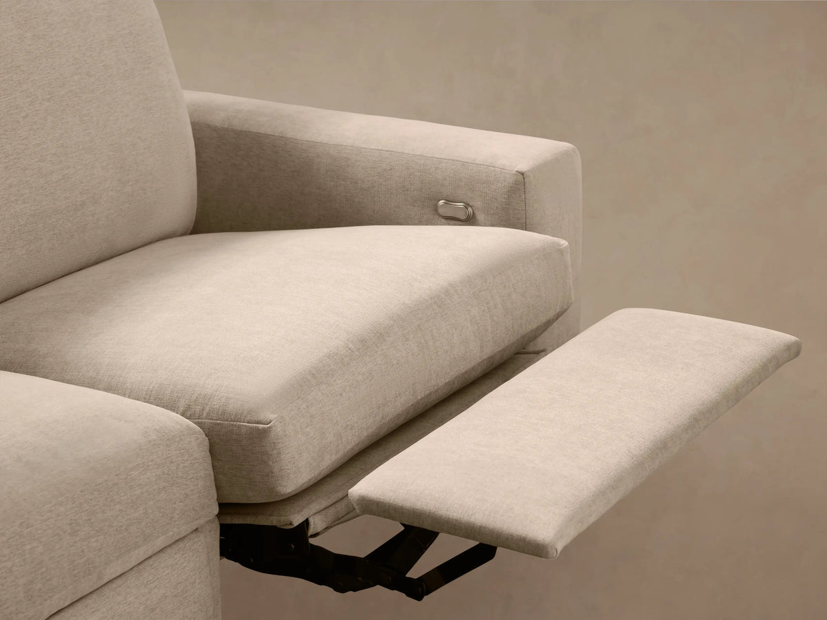 Kipton Wide Arm Motion Sectional: close-up of light beige textured fabric arm with oval metal reclining control.