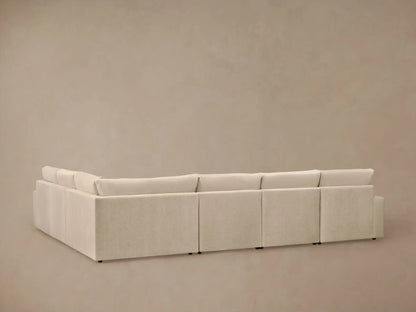 Close-up of Kipton Wide Arm Motion Sectional in light beige fabric, with the footrest extended and silver motion control on arm.