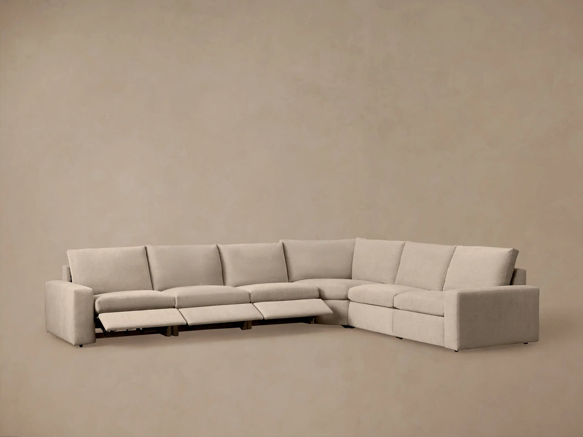 L-shaped Kipton Wide Arm Six Piece Motion Sectional in light beige, showing a reclined section with an extended footrest.