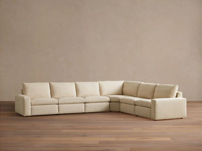 Kipton Wide Arm Six Piece Motion Sectional in beige fabric on wooden floor, featuring six seats in an L-shape with wide arms and plush cushions.