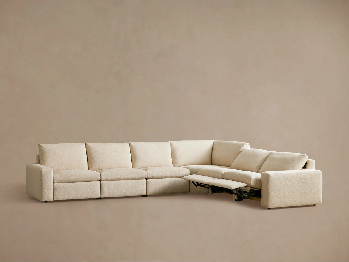The Kipton Wide Arm Six Piece Motion Sectional shown from the back, featuring light beige upholstery and blocky, wide arms.