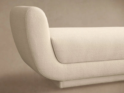 Modern cream Fontana Bench with curved, integrated arms and a textured fabric upholstery, presented against a plain tan wall.