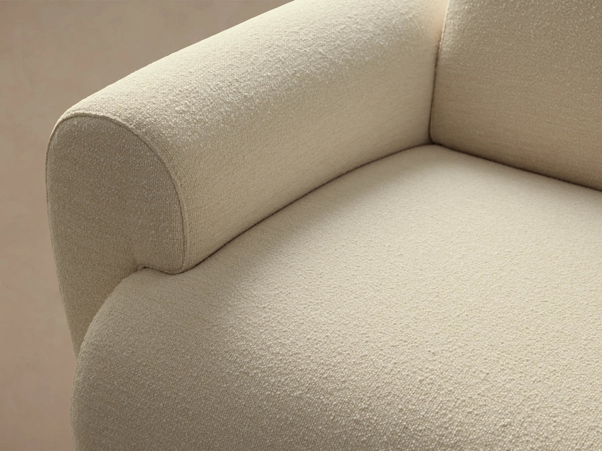 Cream bouclé Gianni Sofa with a modern, rounded design, angled slightly left on a light wood floor.
