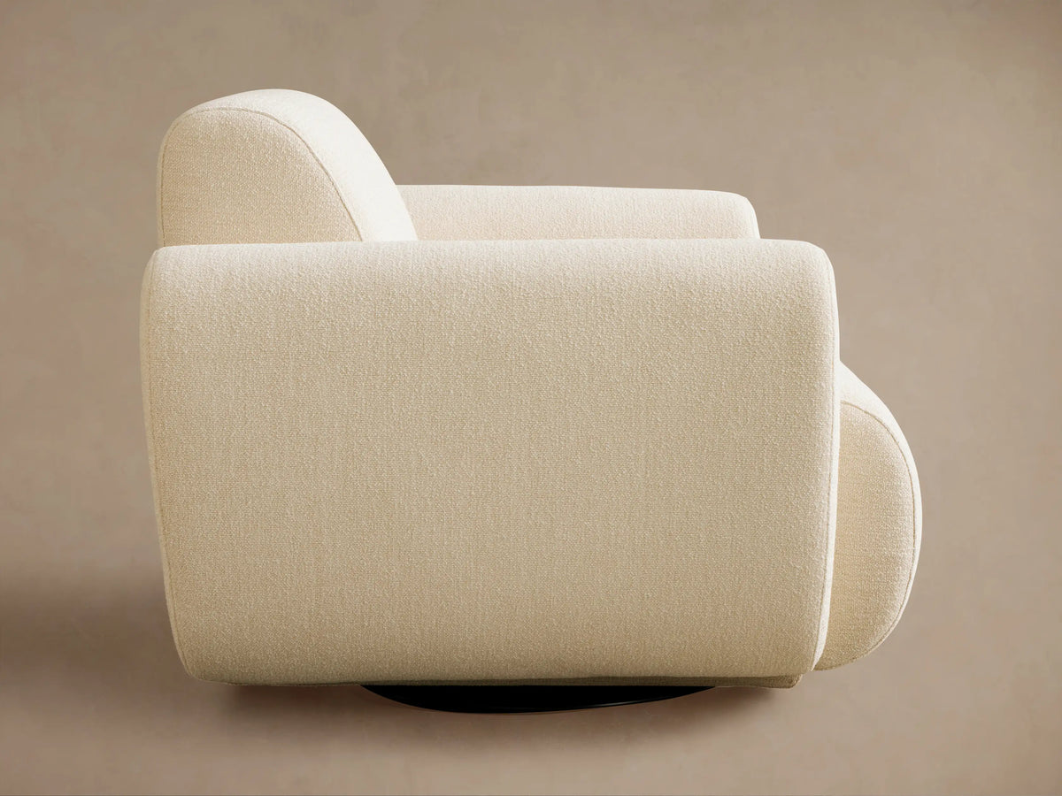 Light cream Gianni Swivel Chair, angled back view. Textured fabric, curved back and armrests, against a plain background.