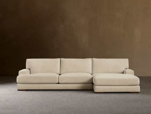 Norwalk Two-Piece Chaise Sectional in beige fabric, featuring a left-facing chaise and three-seat sofa on wooden floor, against a neutral wall.