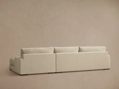 Norwalk Two-Piece Chaise Sectional in a light beige fabric, showing left-arm facing chaise with plush cushions and a solid base.
