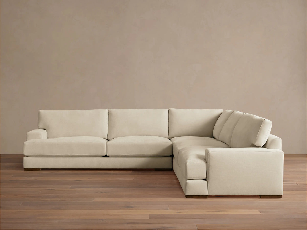 Norwalk Three-Piece Corner Sectional in a neutral tone, featuring plush cushions and a clean, simple design on a wooden floor.