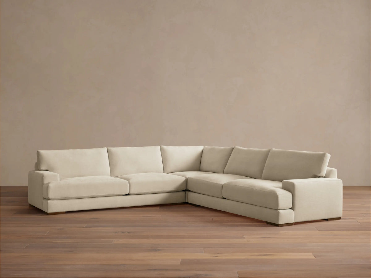 Norwalk Three-Piece Corner Sectional in a neutral tone, featuring plush cushions and a clean, simple design on a wooden floor.