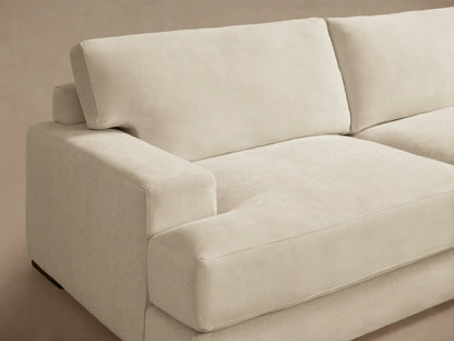 Norwalk Three-Piece Corner Sectional in beige fabric on wooden floor, featuring plush cushions and clean lines, forming an L-shape.