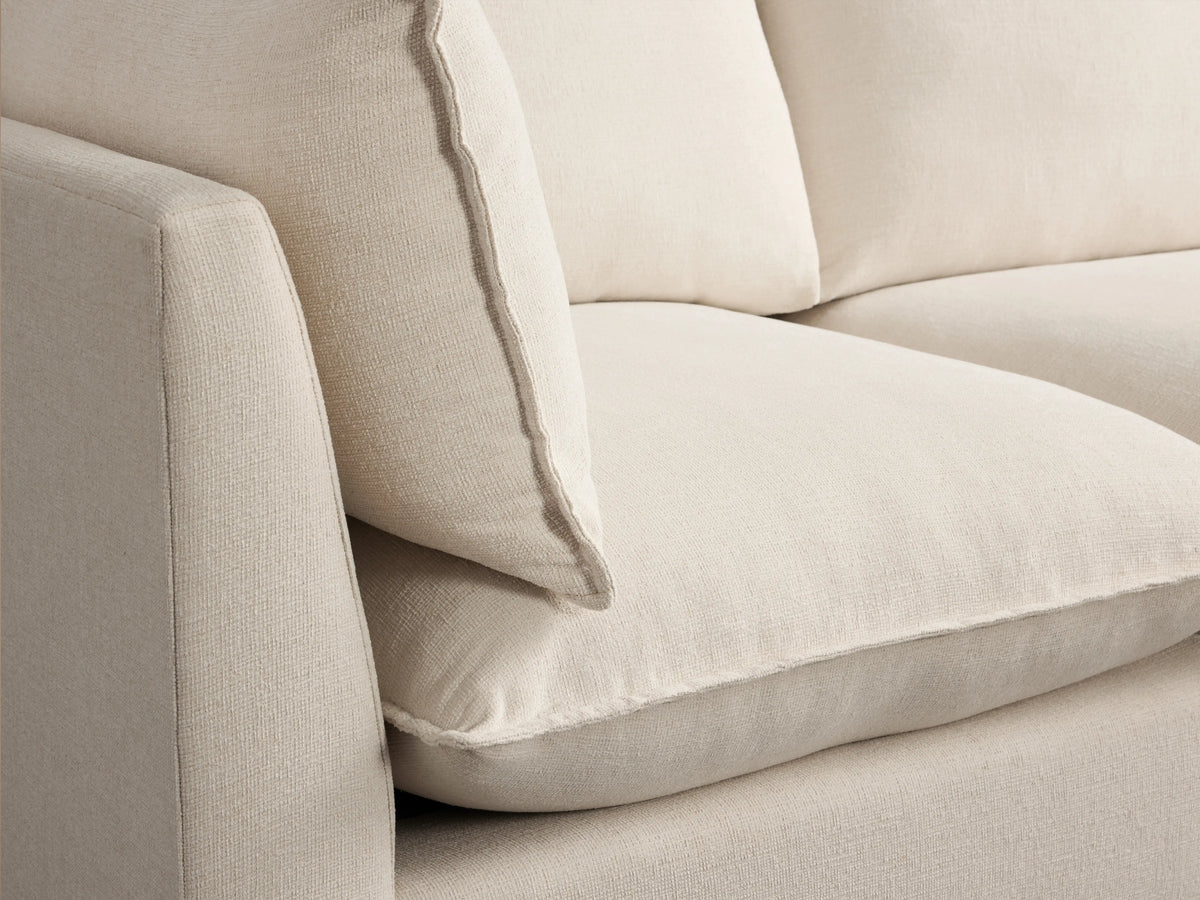 Owen Four-Piece Sectional in cream fabric on a hardwood floor, with three back cushions and a chaise section on the right.