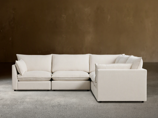 Owen Five-Piece Corner Sectional in cream fabric, featuring plush cushions and soft padding, arranged in an L-shape on wooden flooring.
