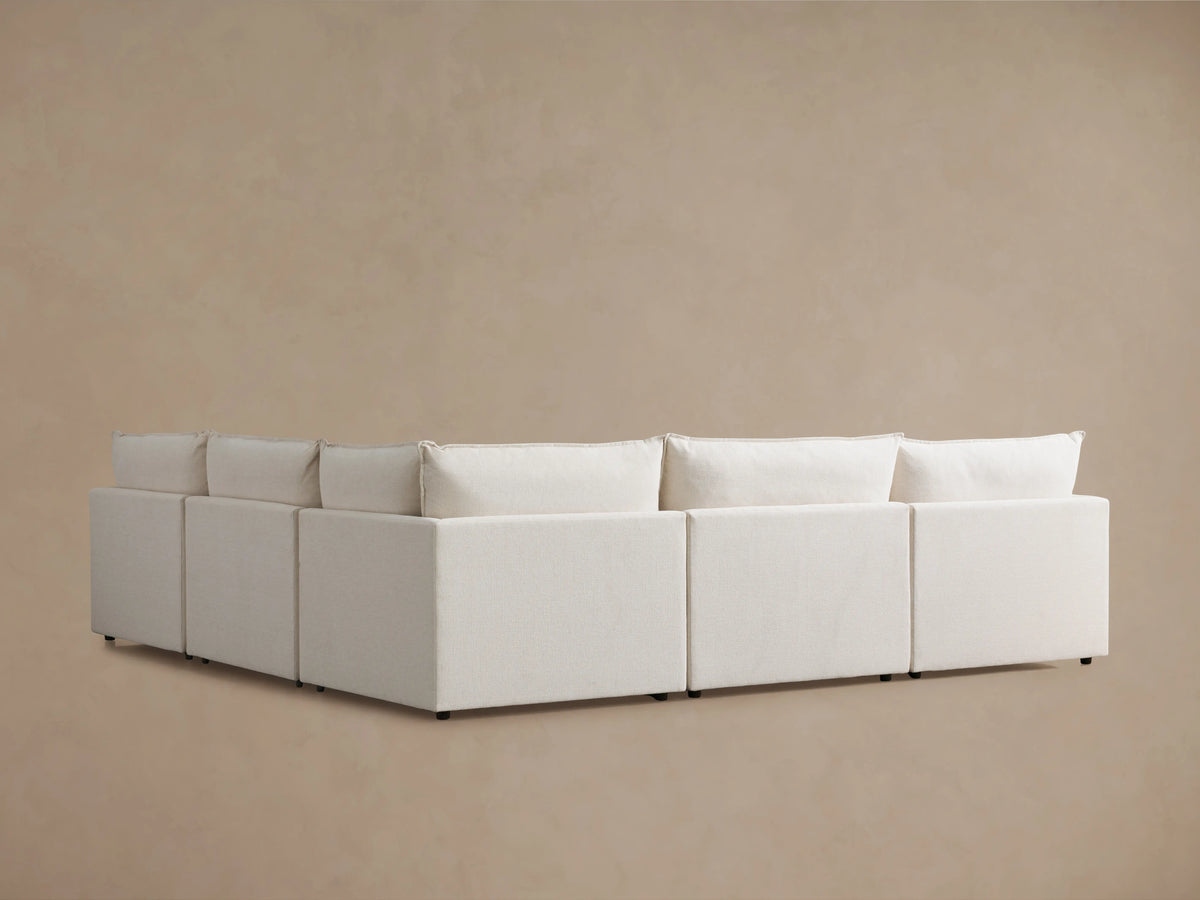 Alt text: Close-up of Owen Five-Piece Corner Sectional in beige fabric, showing soft cushions and angled armrest, emphasizing comfort and craftsmanship.