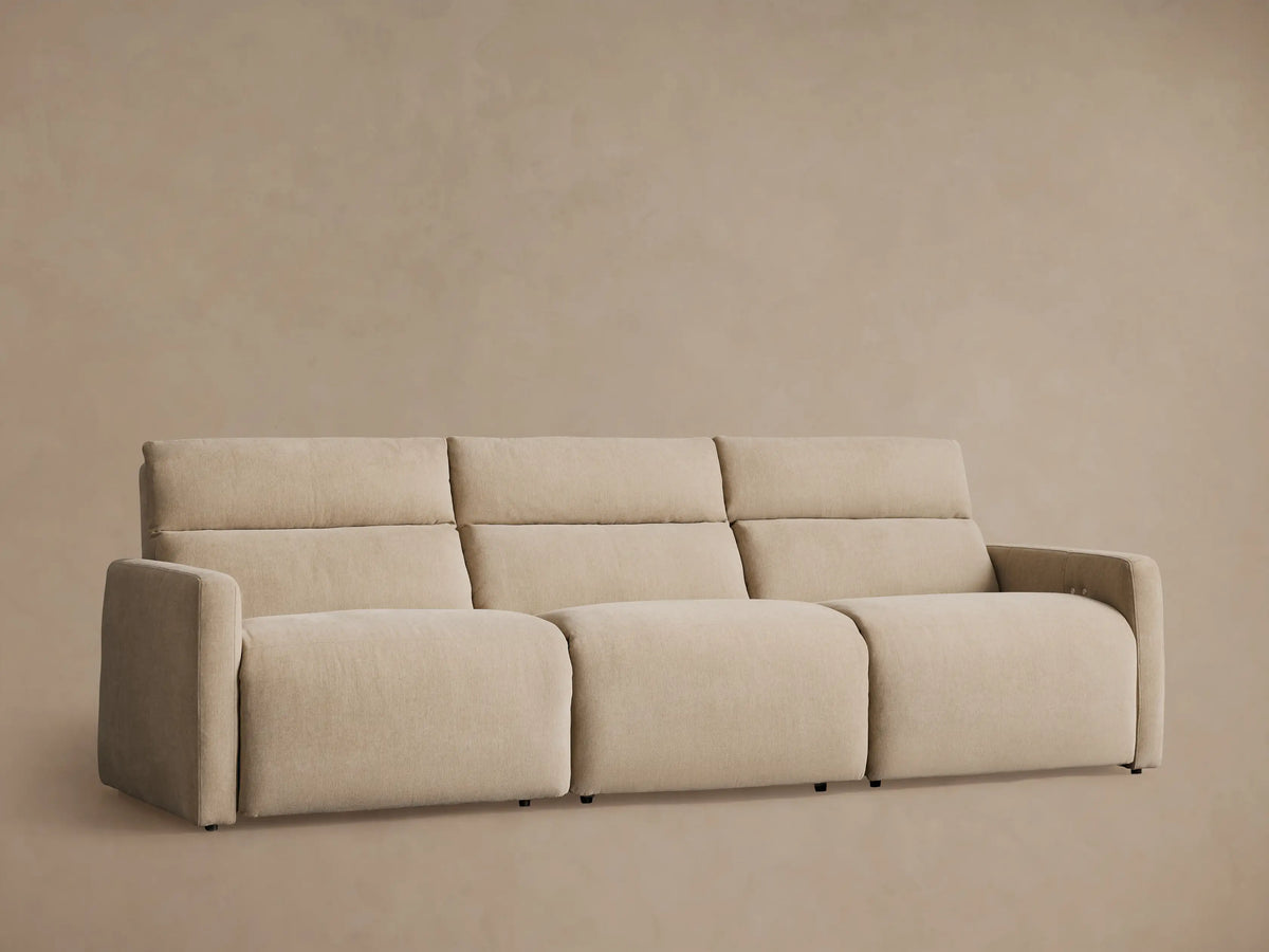 Rowland tailored three-piece motion modular sofa, light beige. Straight-on view on wood floor against light wall.