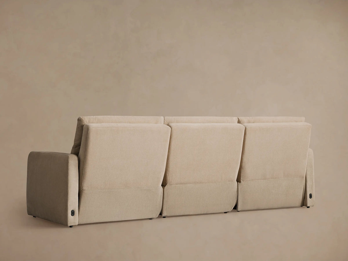 Rowland Tailored Three-Piece Motion Modular Sofa in beige, with the rightmost recliner seat fully extended on a neutral wall.
