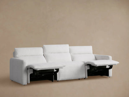 Back view of a light gray Rowland Tailored Three-Piece Motion Modular Sofa with upright backrests against a beige wall.